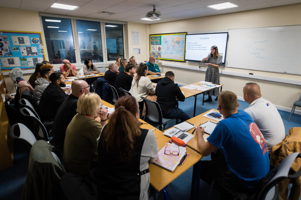 ESOL Students in a classroom, interacting with the tutor at the front of the class