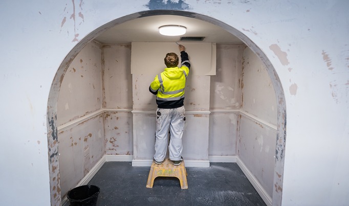 A decorating Apprentice painting a ceiling