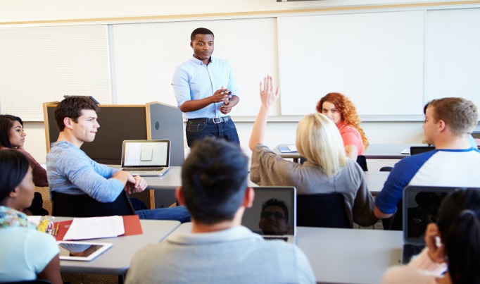 learners in a classroom looking towards a teacher at the front