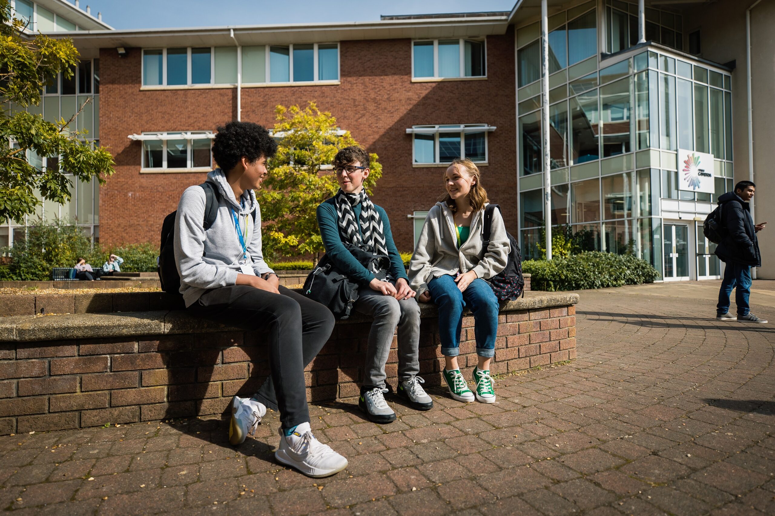 Three Yale Sixth Form students sat down on a wall outside the Sixth Form building