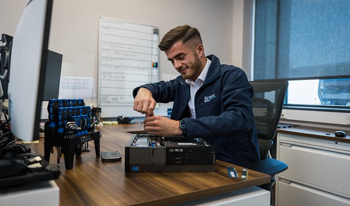 Digital technologies apprentice for ANWYL screwing something on the inside of a computer