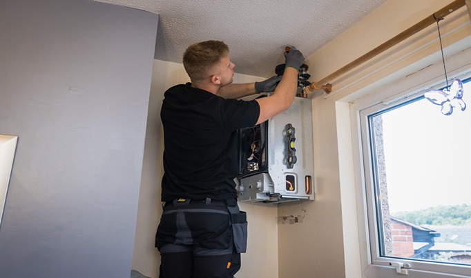 A plumbing apprentice working in a house