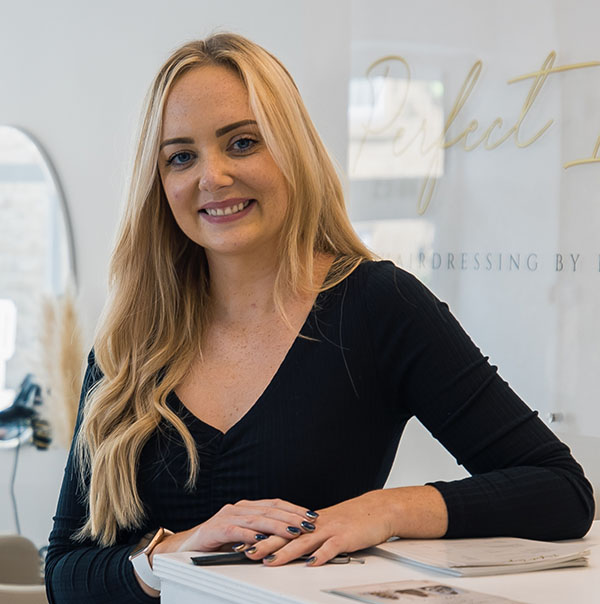 Hairdresser, Kimberly Jones taking a hero shot at her salon looking at the camera