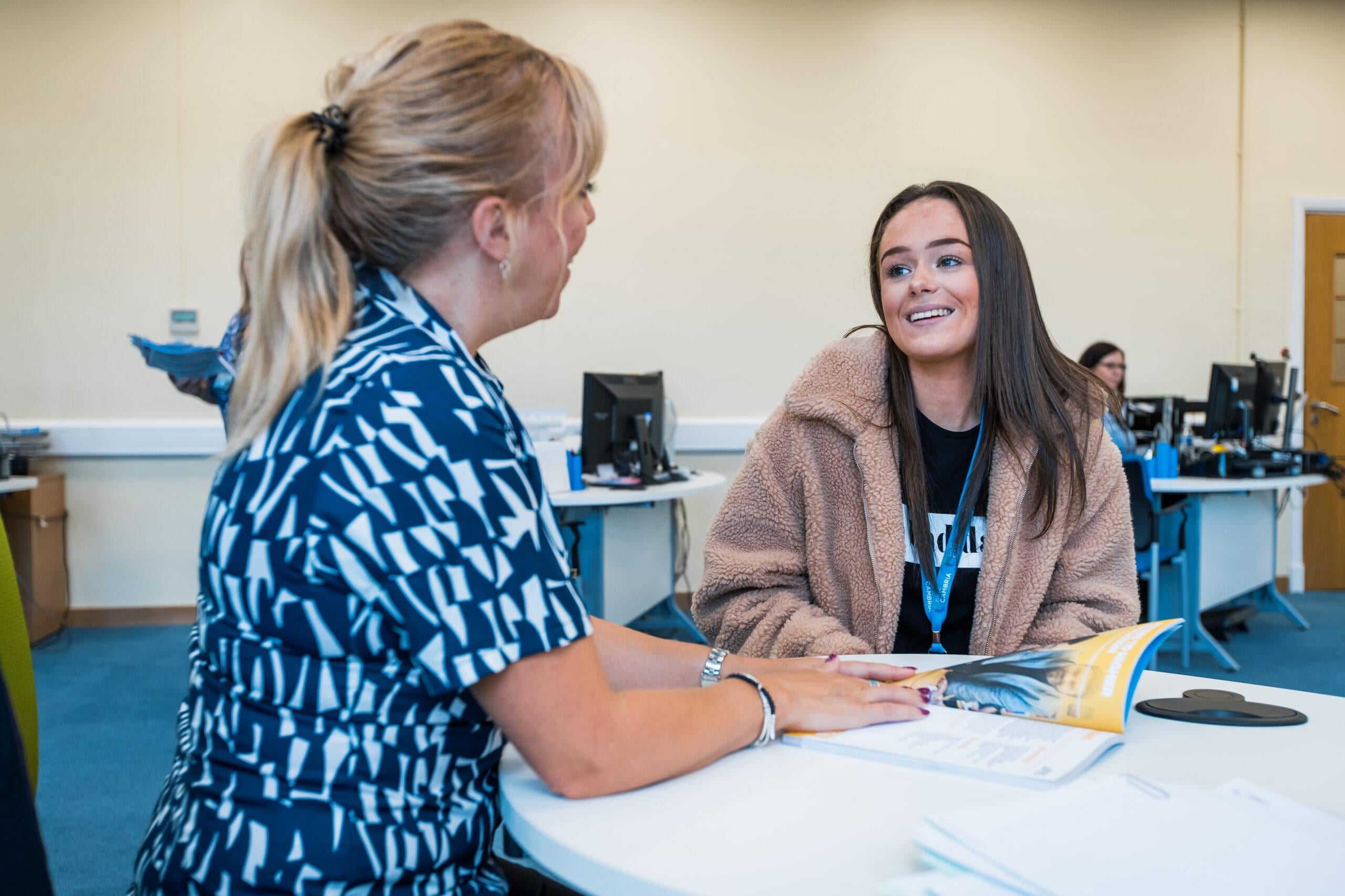 A student speaking with a member of staff