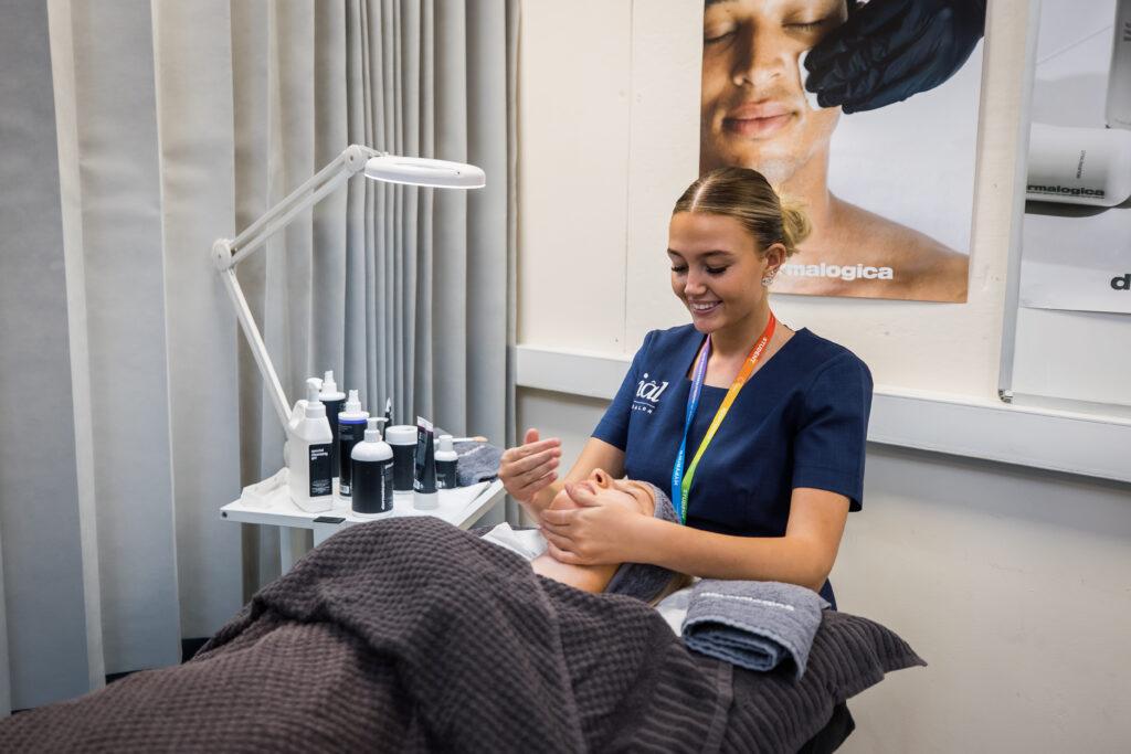 Beauty studies student massaging a clients face