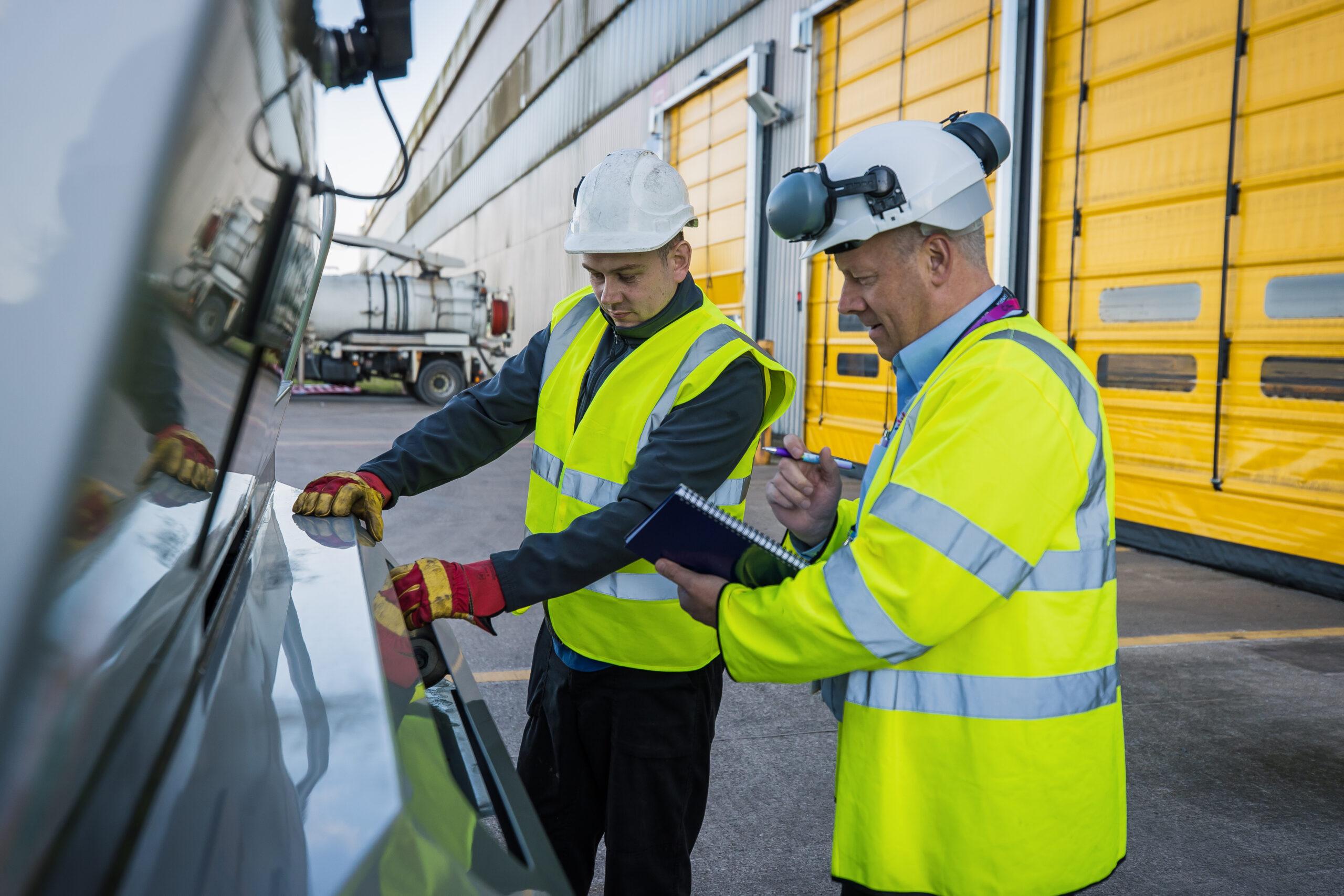 Warehousing apprentice looking at some machinery with their assessor
