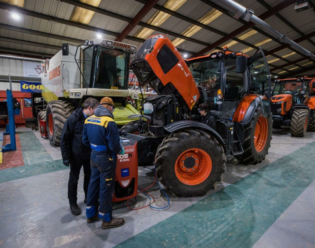 An image of agricultural vehicles, including tractors, quad bikes and harvesters inside a warehouse