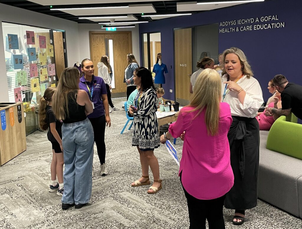 multiple people stood around talking in the Childcare area of Nant building for the news story 'Inspiring the Future of Childcare – Our First Childcare Show a Huge Success'