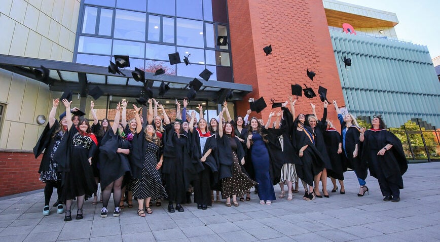 Learners throwing their caps at Cambria University Centre Celebration Event