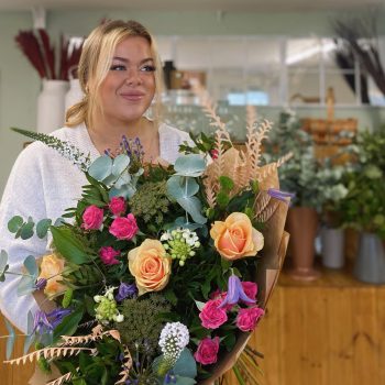 Level 2 & 3 floristry student Bethan Owen taking a hero shot with flowers in her hands