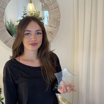 Halle Ennion holding a sttar shaped award looking into the camera