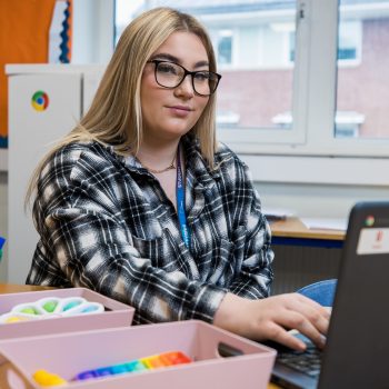 Foundation Learning student Kirsty Parr sat at a desk working on a laptop