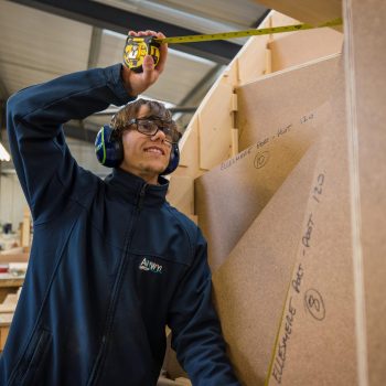 Anwyn Apprentice Joel Thomas using a tape measure to check some work