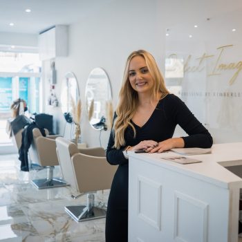 Hairdresser, Kimberly Jones taking a hero shot at her salon looking at the camera