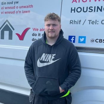 Level 3 Plumbing and Gas Apprentice Ryan Hanley standing infront of a work van smiling